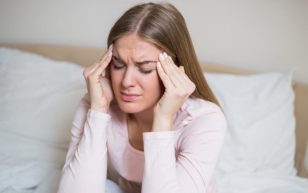 Woman suffering from a headache contemplating seeing a neurologist.